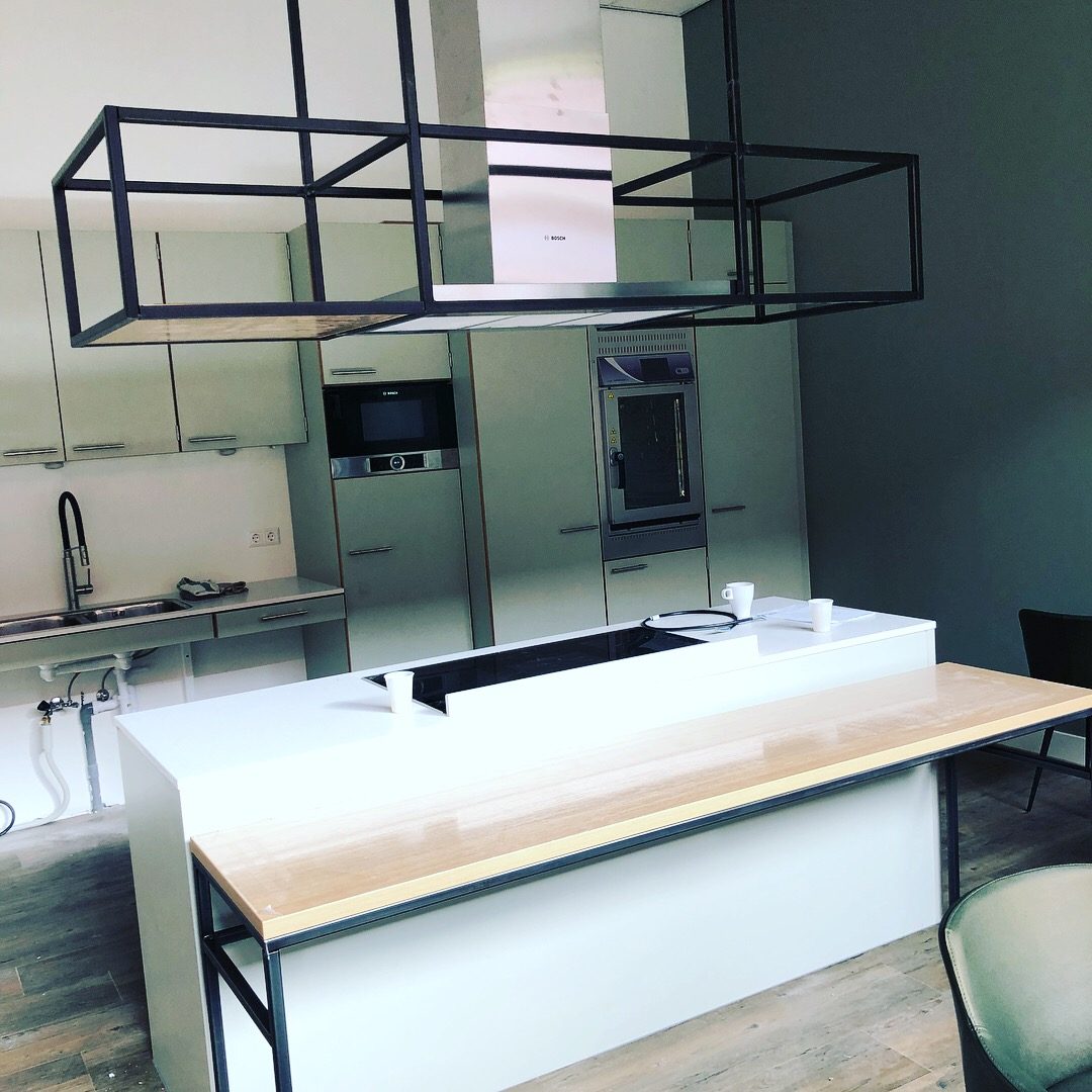 Zwart stalen frame dat boven een keukeneiland hangt