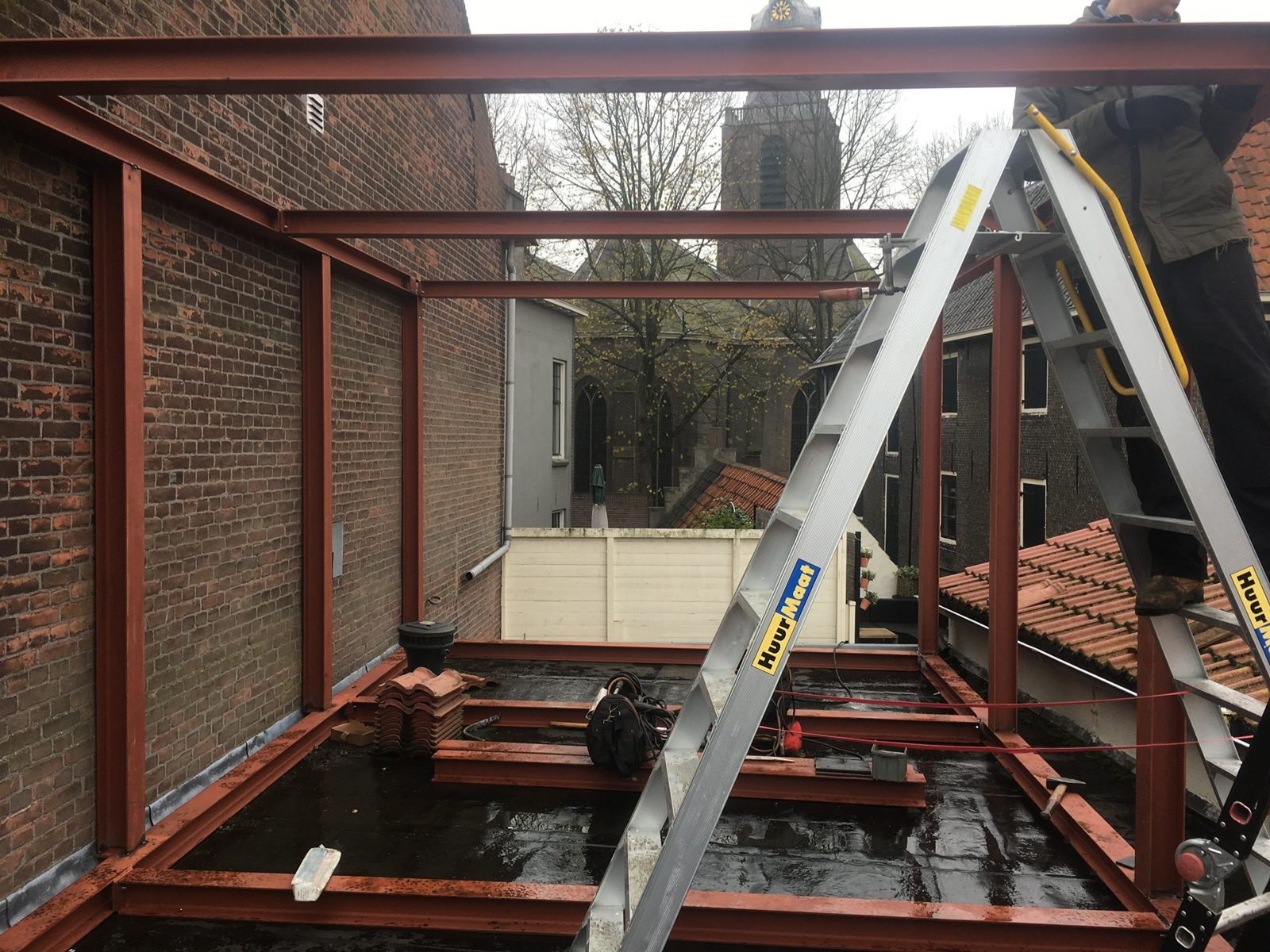 Gegronde staalconstructie op een plat dak, met een ladder ernaast