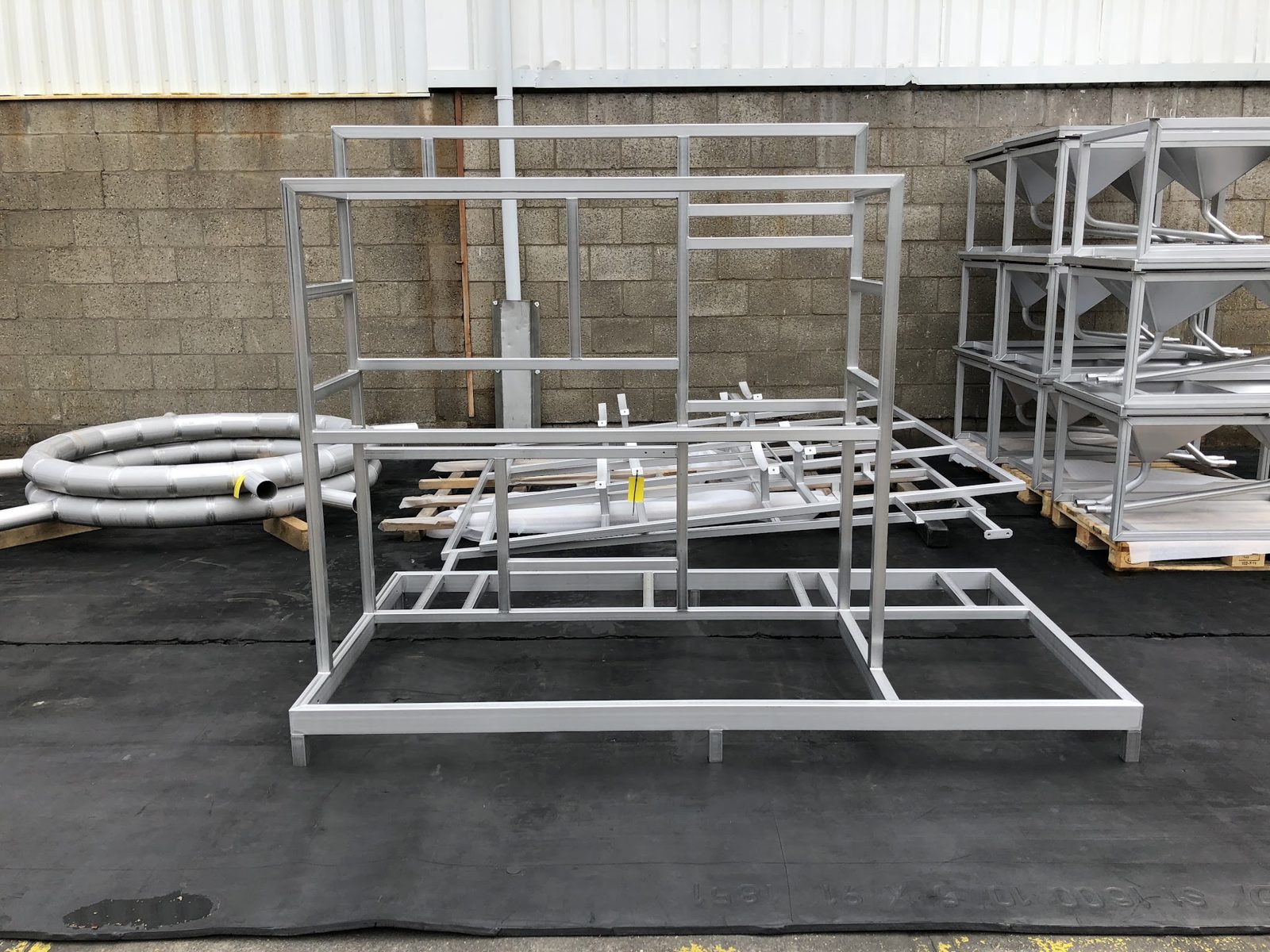 Aluminium frames en opgerolde buizen buiten op pallets